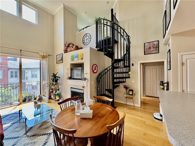 1000 Providence Pl Unit 449, Providence, RI 02903 - dining area featuring a towering ceiling, stairway, crown molding, light wood-type flooring, and a tile fireplace