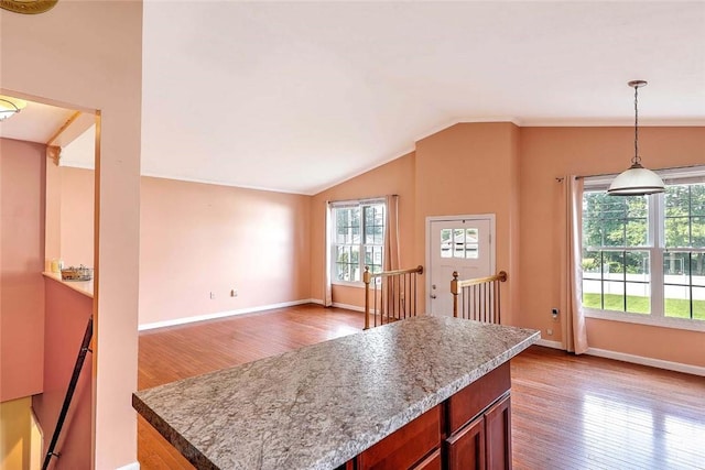 28 Plant St, Cumberland, RI 02864 - kitchen with wood finished floors, decorative light fixtures, vaulted ceiling, a center island, and light countertops