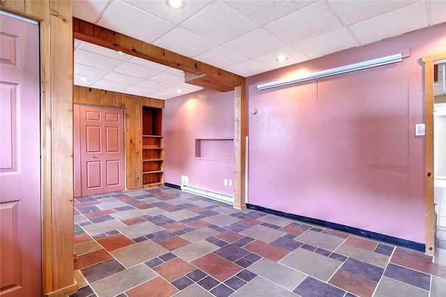 28 Plant St, Cumberland, RI 02864 - finished below grade area featuring built in shelves, a baseboard heating unit, wooden walls, a paneled ceiling, and recessed lighting