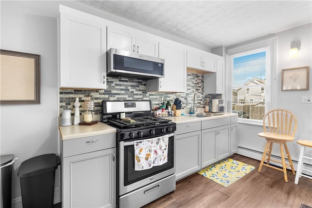 38 Vine St, East Providence, RI 02914 - kitchen with appliances with stainless steel finishes, decorative backsplash, dark wood-style flooring, light countertops, and a textured ceiling