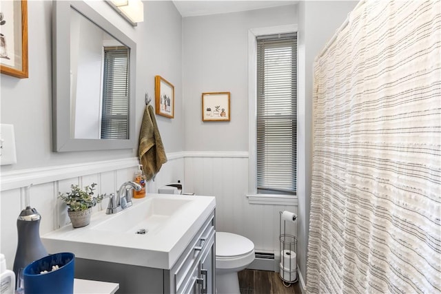 38 Vine St, East Providence, RI 02914 - full bath featuring a wainscoted wall, vanity, a baseboard heating unit, and wood finished floors