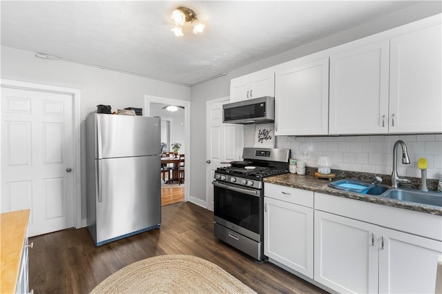 38 Vine St, East Providence, RI 02914 - kitchen with stainless steel appliances, dark wood finished floors, backsplash, and white cabinetry