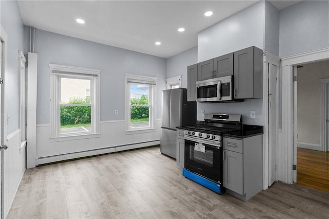 230 Pawtucket Ave, Pawtucket, RI 02860 - kitchen featuring stainless steel appliances, a baseboard radiator, dark countertops, light wood-style flooring, and gray cabinets