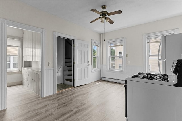 230 Pawtucket Ave, Pawtucket, RI 02860 - kitchen featuring a ceiling fan, light wood-style flooring, a wainscoted wall, range with gas cooktop, and freestanding refrigerator