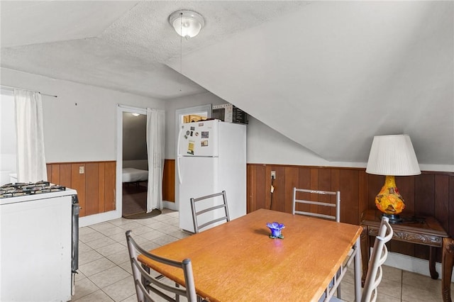 230 Pawtucket Ave, Pawtucket, RI 02860 - dining area with a textured ceiling, light tile patterned floors, wainscoting, lofted ceiling, and wood walls