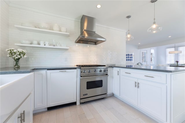 21 Overlook Ave, Charlestown, RI 02813 - kitchen featuring luxury stove, wall chimney exhaust hood, a peninsula, decorative backsplash, and white cabinetry