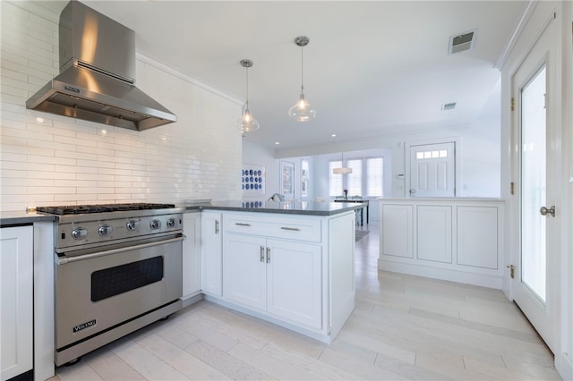 21 Overlook Ave, Charlestown, RI 02813 - kitchen with premium range, exhaust hood, a peninsula, tasteful backsplash, and white cabinets
