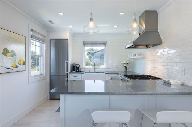 21 Overlook Ave, Charlestown, RI 02813 - kitchen featuring high end refrigerator, range hood, dark stone counters, decorative backsplash, and ornamental molding