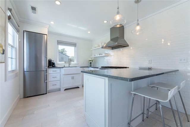 21 Overlook Ave, Charlestown, RI 02813 - kitchen with high end fridge, dark countertops, a peninsula, white cabinets, and crown molding
