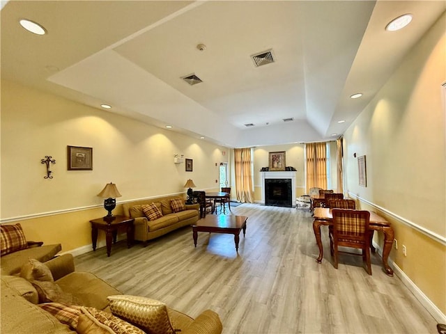 106 Mill St Unit 102, Woonsocket, RI 02895 - living room featuring light wood-style floors, a fireplace with raised hearth, recessed lighting, a tray ceiling, and lofted ceiling