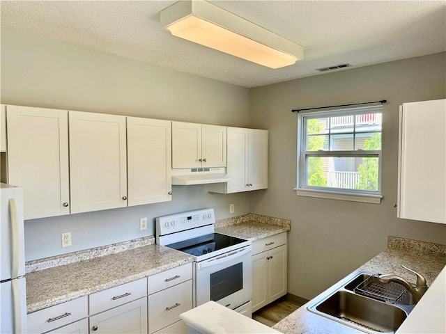 106 Mill St Unit 102, Woonsocket, RI 02895 - kitchen with white appliances, white cabinets, light countertops, and a textured ceiling