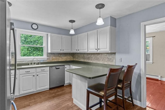 43 Peckham Pl, Bristol, RI 02809 - kitchen with stainless steel appliances, a baseboard radiator, white cabinetry, and decorative backsplash