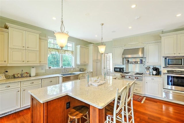 25 Brayton Point Rd, Westport, MA 02790 - kitchen with appliances with stainless steel finishes, wall chimney exhaust hood, a warming drawer, a breakfast bar, and a center island