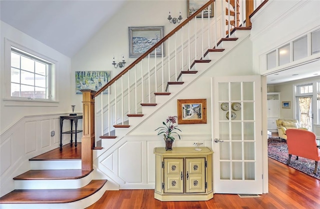 25 Brayton Point Rd, Westport, MA 02790 - stairway featuring high vaulted ceiling, wood finished floors, a decorative wall, and a wainscoted wall