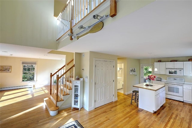 25 Brayton Point Rd, Westport, MA 02790 - kitchen with white appliances, white cabinets, light wood finished floors, and a high ceiling