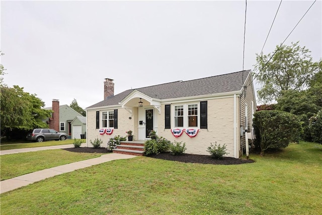 72 Audubon Rd, Warwick, RI 02888 - view of front of home featuring a chimney, a front yard, and brick siding