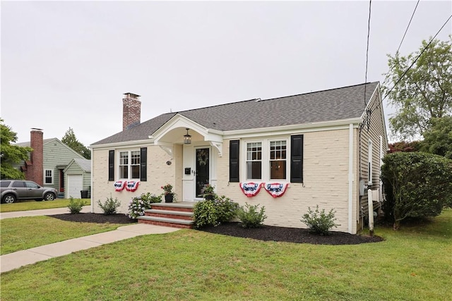 72 Audubon Rd, Warwick, RI 02888 - view of front facade with a chimney, a front lawn, brick siding, a garage, and roof with shingles