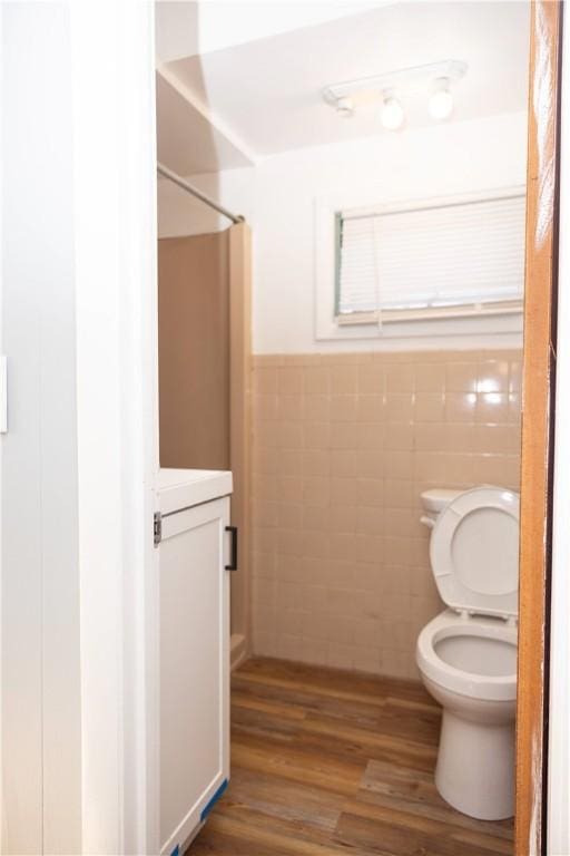 89 Warren Ave, East Providence, RI 02914 - bathroom featuring tile walls, wood finished floors, a wainscoted wall, and a shower