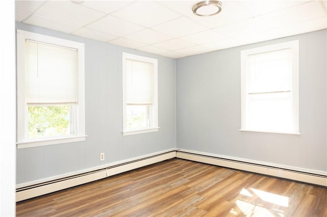 89 Warren Ave, East Providence, RI 02914 - unfurnished room with a baseboard heating unit, a drop ceiling, and wood finished floors