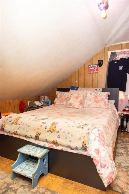89 Warren Ave, East Providence, RI 02914 - bedroom with lofted ceiling, wood walls, and wood finished floors