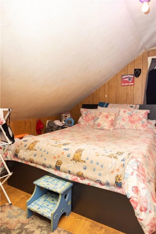 89 Warren Ave, East Providence, RI 02914 - bedroom with lofted ceiling, wooden walls, and wood finished floors