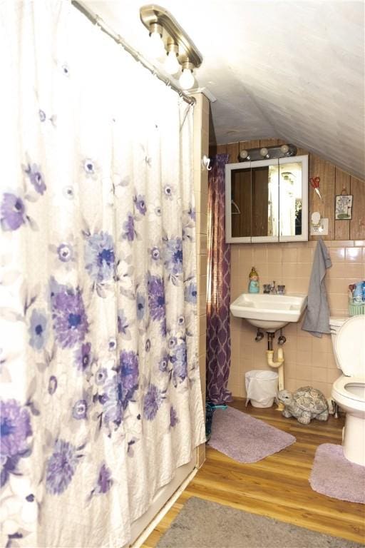 89 Warren Ave, East Providence, RI 02914 - full bathroom featuring tile walls, wood finished floors, vaulted ceiling, and curtained shower