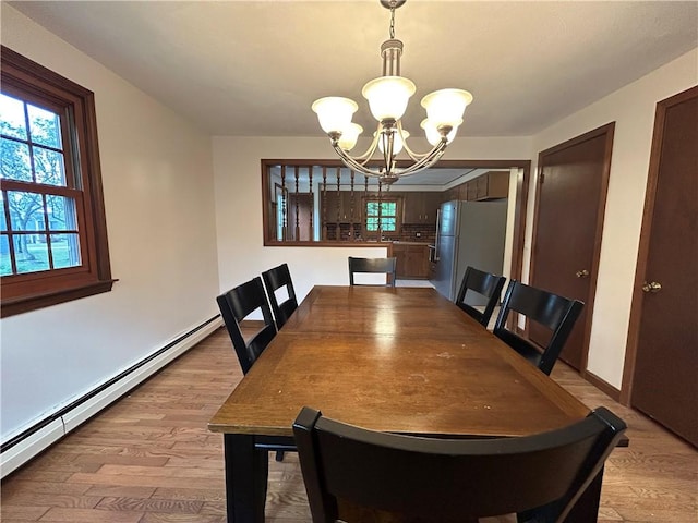80 Silverwood Ln, West Warwick, RI 02893 - dining area with a baseboard heating unit, a chandelier, and light wood-style floors