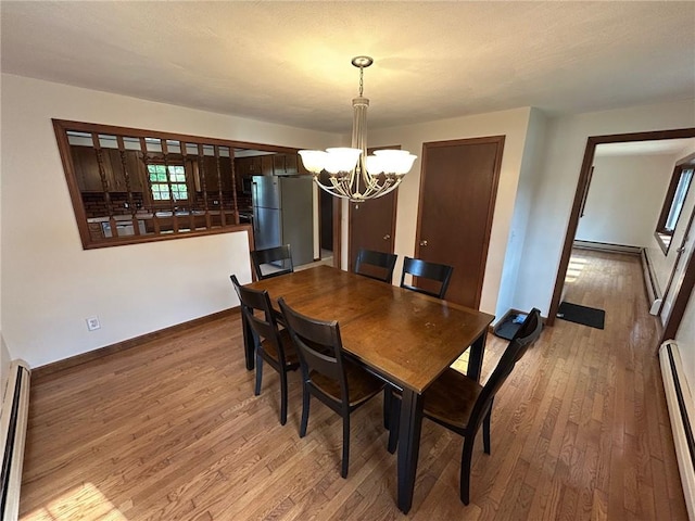 80 Silverwood Ln, West Warwick, RI 02893 - dining space with a chandelier, wood-type flooring, baseboard heating, and a baseboard radiator