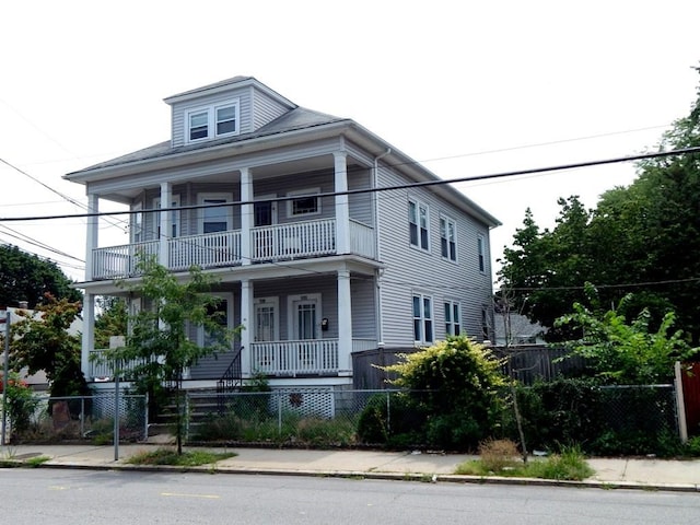 598 Admiral St, Providence, RI 02908 - view of front of house featuring a balcony, a fenced front yard, and a porch