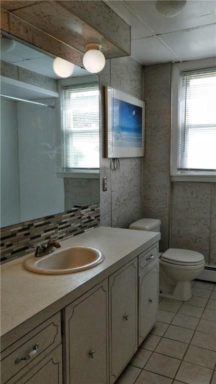 598 Admiral St, Providence, RI 02908 - bathroom featuring tile patterned floors, vanity, and tasteful backsplash