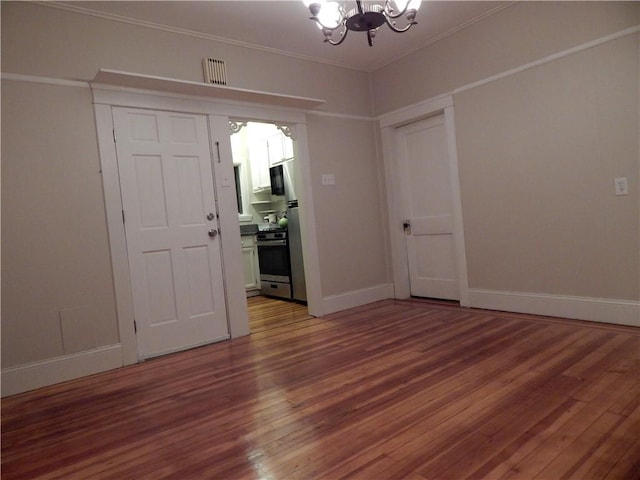 598 Admiral St, Providence, RI 02908 - spare room with a chandelier, wood finished floors, and crown molding