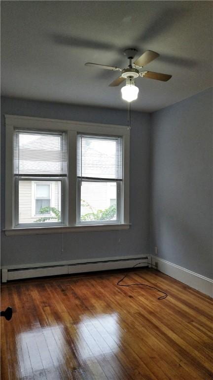 598 Admiral St, Providence, RI 02908 - empty room featuring a baseboard radiator, dark wood finished floors, and a ceiling fan