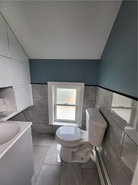 57 Merino St, Johnston, RI 02919 - half bathroom featuring tile walls, baseboard heating, vanity, and vaulted ceiling