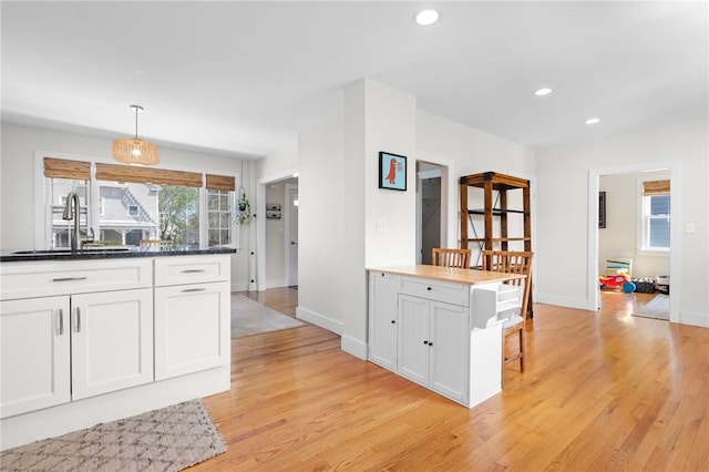 92 Franklin St, Bristol, RI 02809 - kitchen featuring light wood-style floors, recessed lighting, white cabinetry, decorative light fixtures, and dark countertops