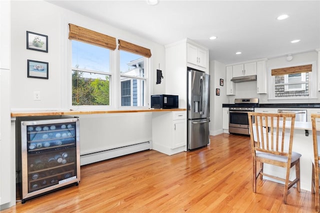 92 Franklin St, Bristol, RI 02809 - kitchen with appliances with stainless steel finishes, baseboard heating, wine cooler, white cabinets, and recessed lighting