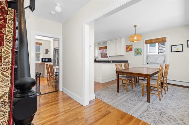 92 Franklin St, Bristol, RI 02809 - dining space with light wood-style floors, healthy amount of natural light, and baseboard heating