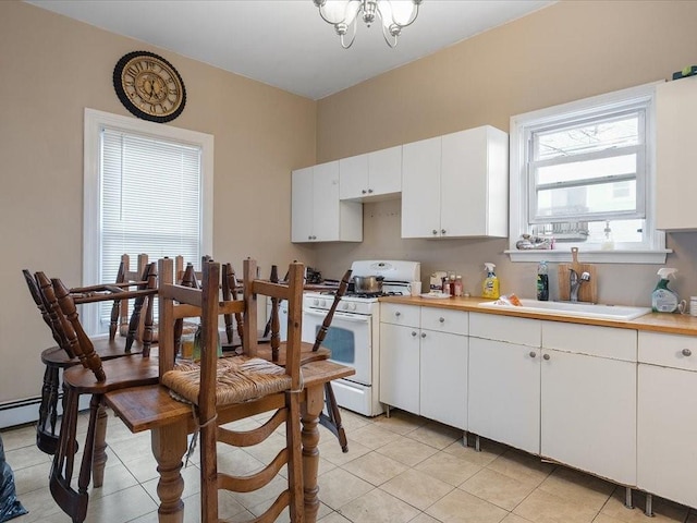 54 Harrison St, Pawtucket, RI 02860 - kitchen featuring white range with gas stovetop, light countertops, light tile patterned floors, and white cabinetry