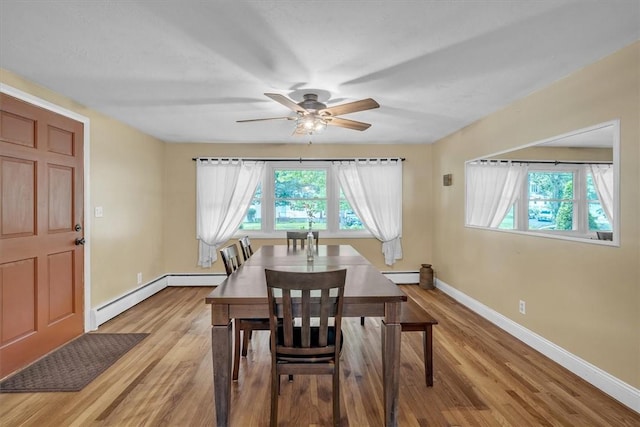 144 Hines Rd, Cumberland, RI 02864 - dining area featuring healthy amount of natural light, a baseboard heating unit, a ceiling fan, and light wood-style flooring