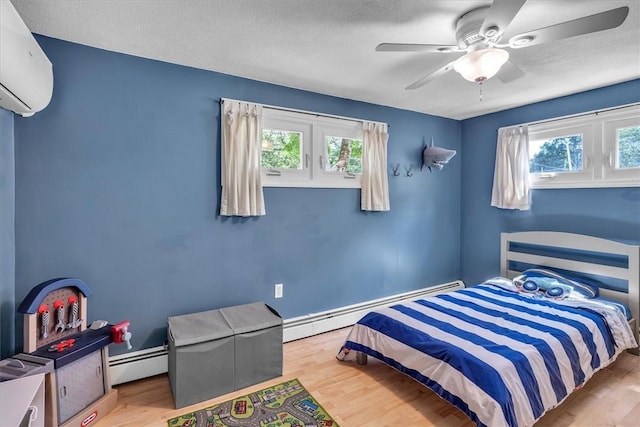 144 Hines Rd, Cumberland, RI 02864 - bedroom with baseboard heating, an AC wall unit, multiple windows, and a textured ceiling