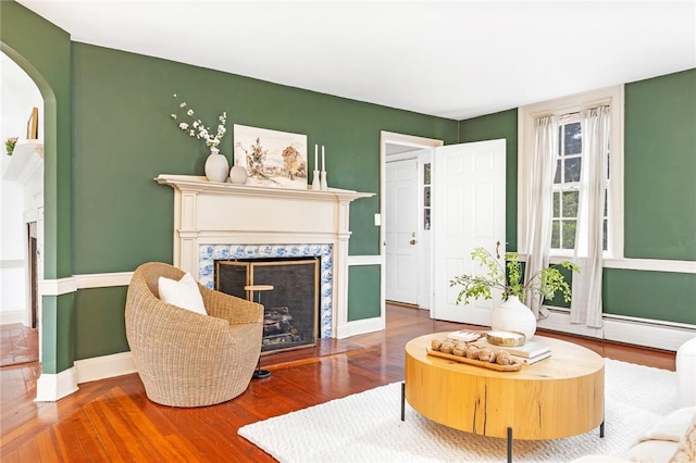 603 E Ave, Pawtucket, RI 02860 - living area with a high end fireplace, wood finished floors, arched walkways, and baseboard heating