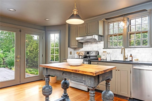 603 E Ave, Pawtucket, RI 02860 - kitchen with stainless steel appliances, under cabinet range hood, decorative backsplash, light wood-style floors, and wooden counters
