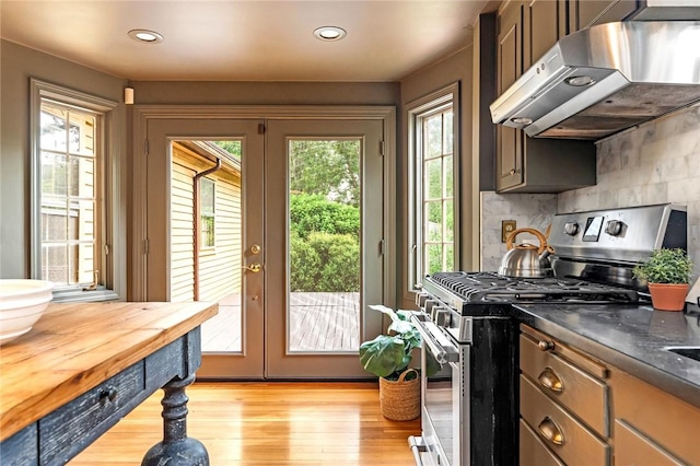 603 E Ave, Pawtucket, RI 02860 - kitchen featuring stainless steel gas range oven, under cabinet range hood, french doors, tasteful backsplash, and light wood-style floors