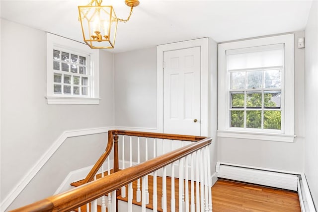 603 E Ave, Pawtucket, RI 02860 - hall featuring a chandelier, baseboard heating, wood finished floors, a baseboard heating unit, and an upstairs landing