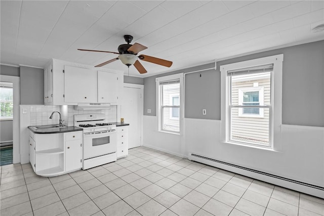 289 Mowry St, Woonsocket, RI 02895 - kitchen with white gas stove, a baseboard heating unit, open shelves, dark countertops, and healthy amount of natural light