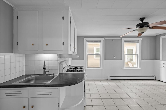 289 Mowry St, Woonsocket, RI 02895 - kitchen with gas range gas stove, dark countertops, baseboard heating, white cabinets, and a ceiling fan