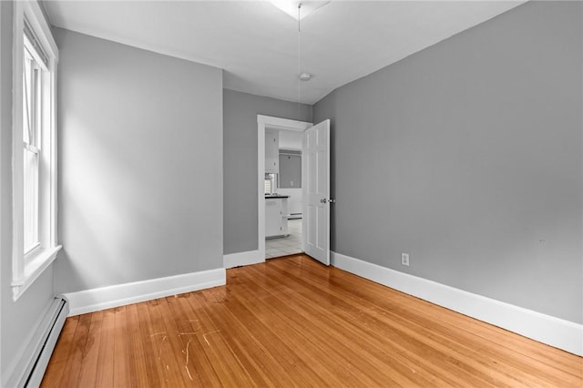 289 Mowry St, Woonsocket, RI 02895 - unfurnished bedroom featuring a baseboard heating unit and light wood-style floors