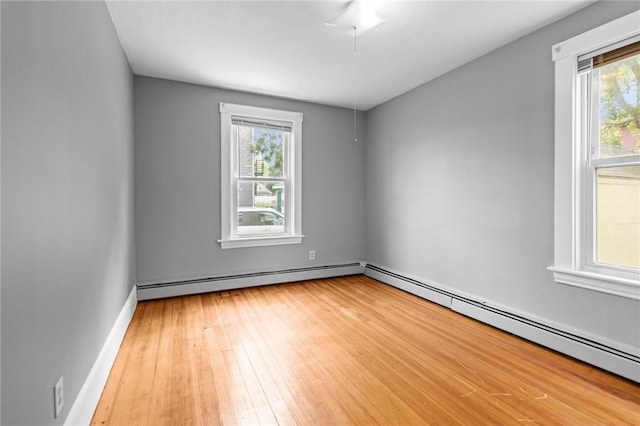 289 Mowry St, Woonsocket, RI 02895 - empty room featuring a baseboard radiator, plenty of natural light, and light wood finished floors