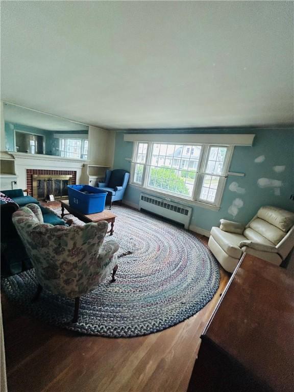 51 Benjamin St, Pawtucket, RI 02861 - living room featuring wood finished floors, a fireplace, and baseboard heating