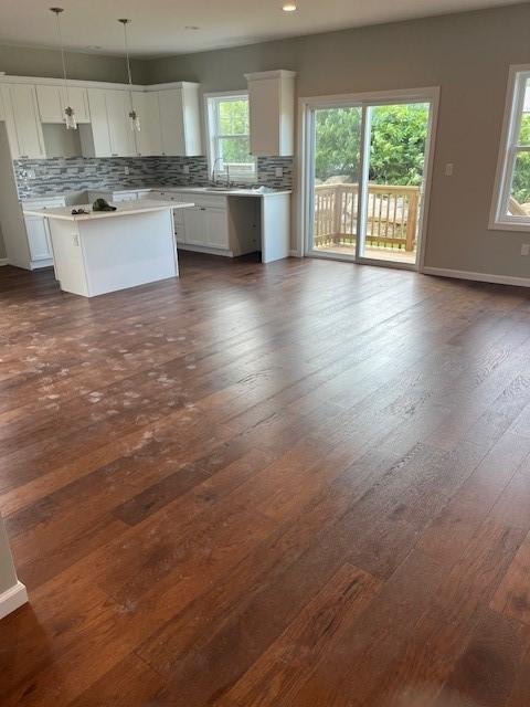 99 Ayda Rose Ave, West Warwick, RI 02893 - kitchen featuring backsplash, plenty of natural light, white cabinets, and a center island