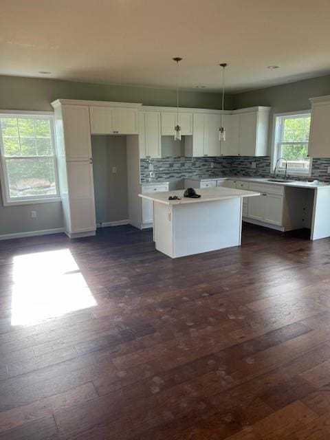 99 Ayda Rose Ave, West Warwick, RI 02893 - kitchen featuring a kitchen island, white cabinets, decorative backsplash, dark wood-style floors, and light countertops